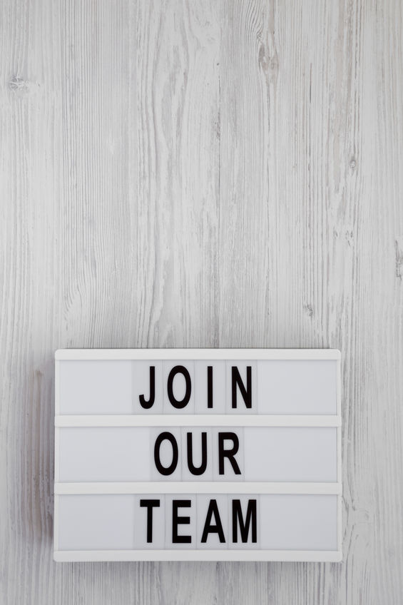 'Join our team' words on a modern board on a white wooden background, top view. Overhead, from above, flat lay. Copy space.